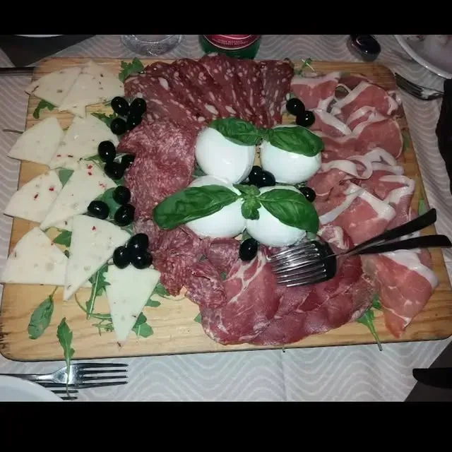 Spaghetti alla carbonara con pancetta croccante su un piatto bianco.