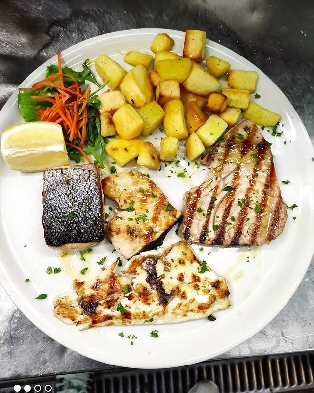 Piatto di pesce alla griglia (salmone e tonno), patate arrosto, verdure e limone.