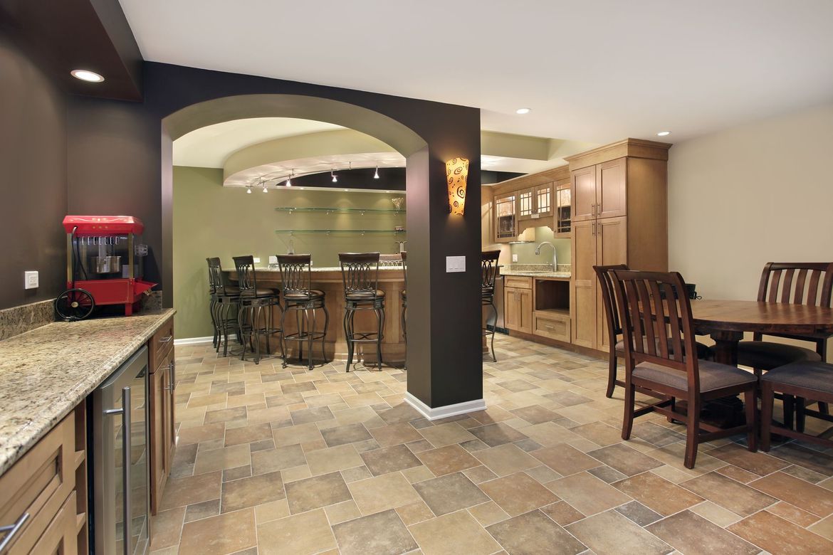 A basement with a table and chairs and a popcorn machine