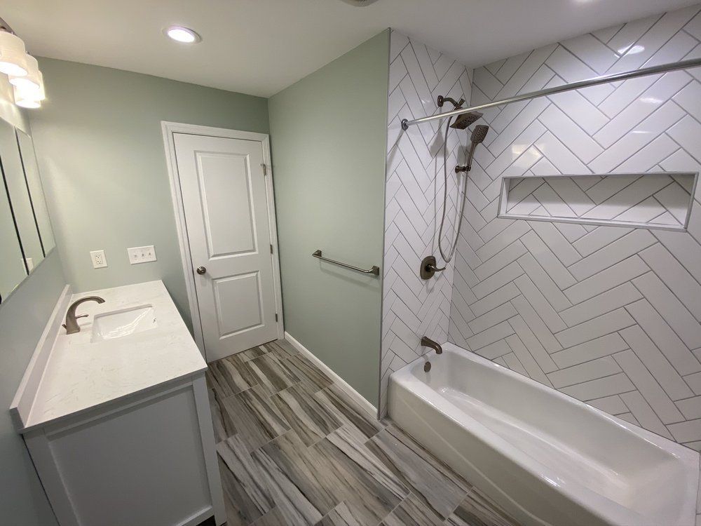 A bathroom with a bathtub , sink and shower.