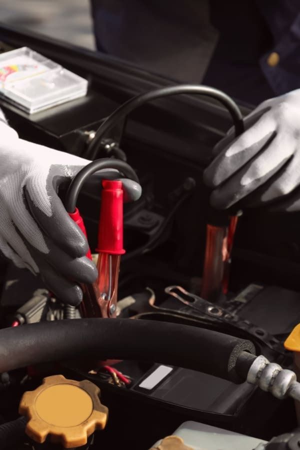 mechanic changing battery in white gloves