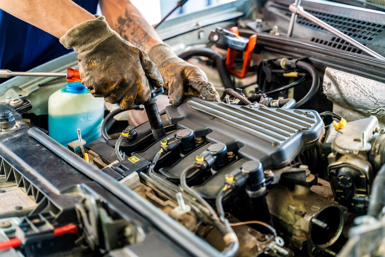 A man is working on the engine of a car.