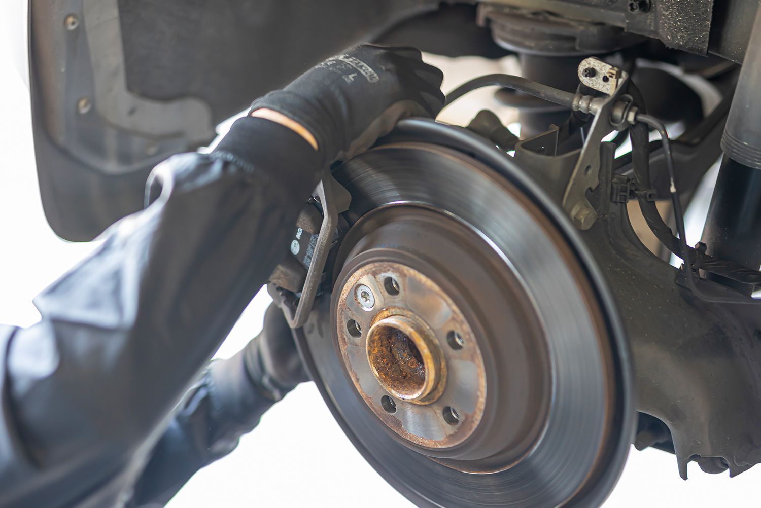 A person is working on the brake disc of a car.