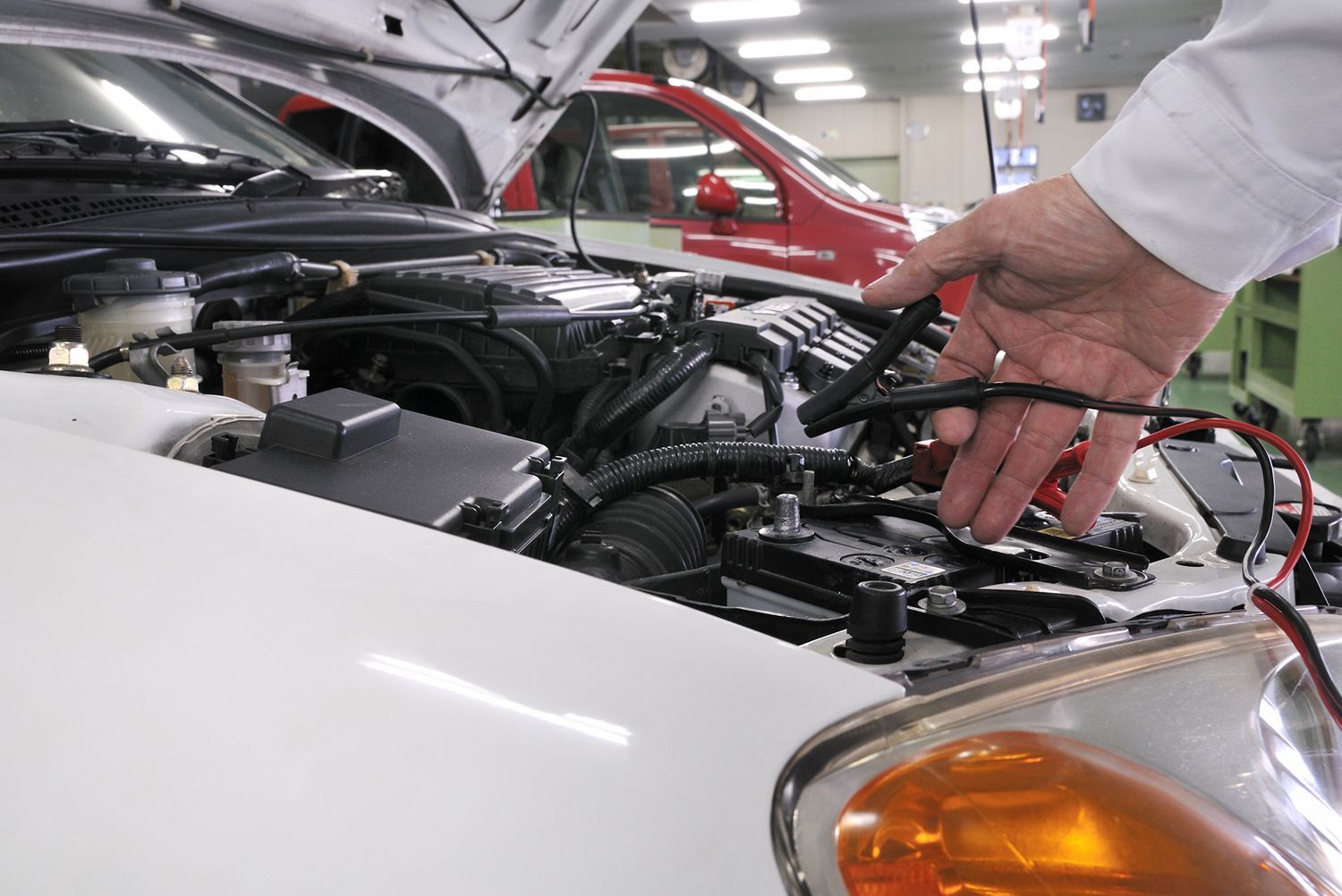 A person is working on the engine of a car in a garage.