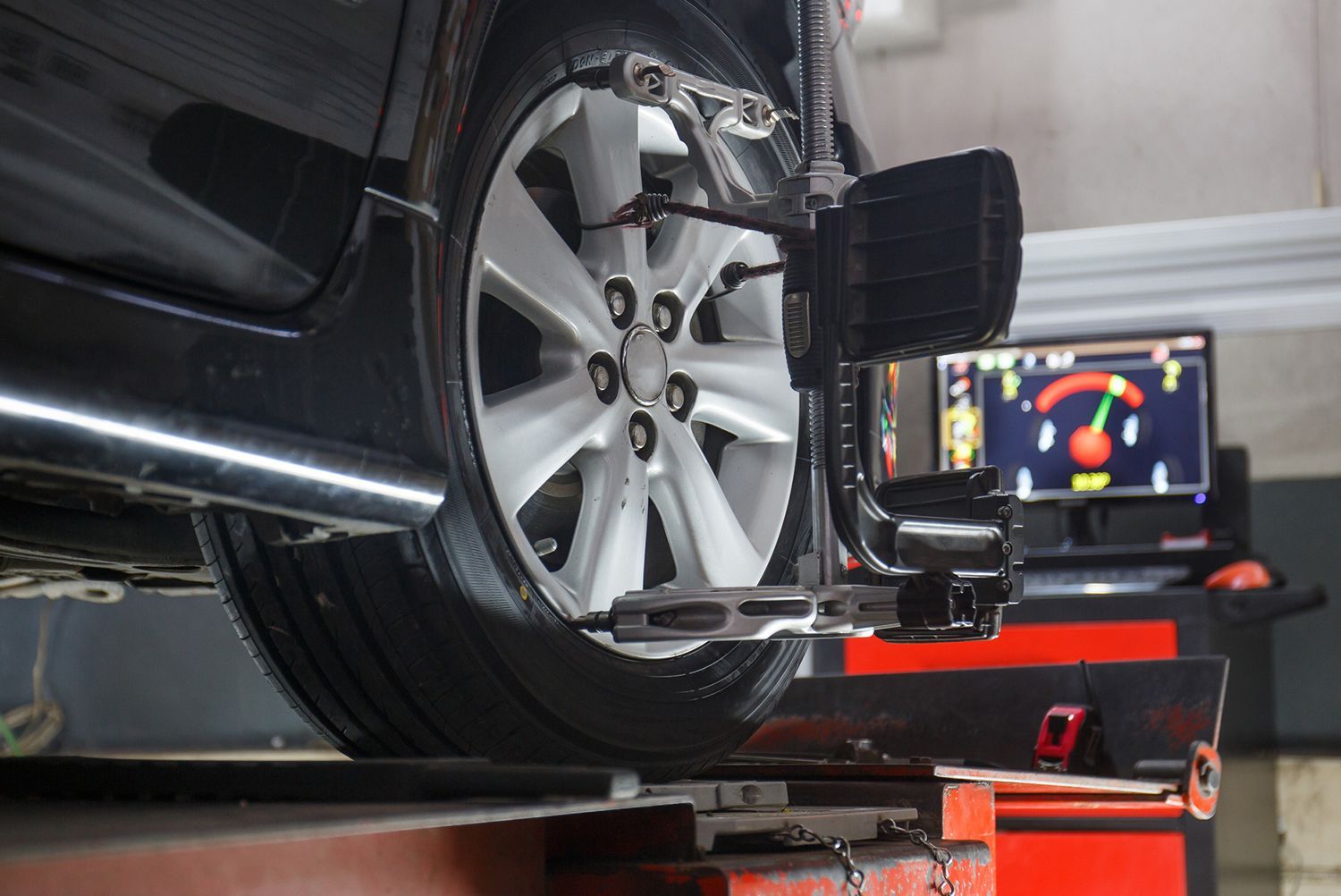 A car is being aligned with a machine in a garage.