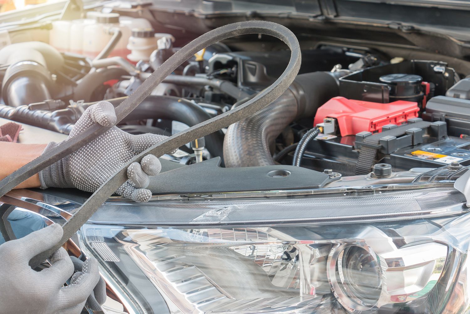 A person is working on the engine of a car.