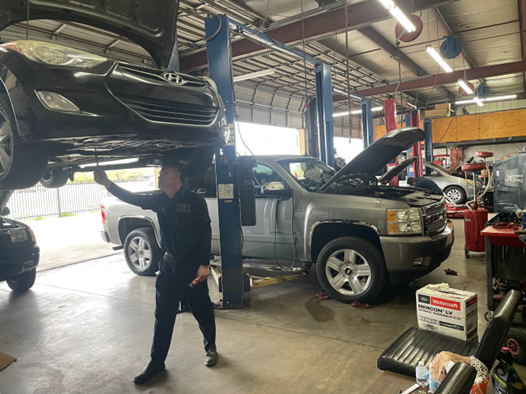 A man is working on a car in a garage.