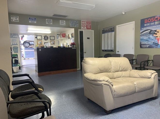 A waiting room with a couch and chairs in it