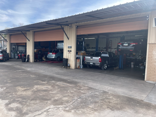 A row of cars are parked in a garage.