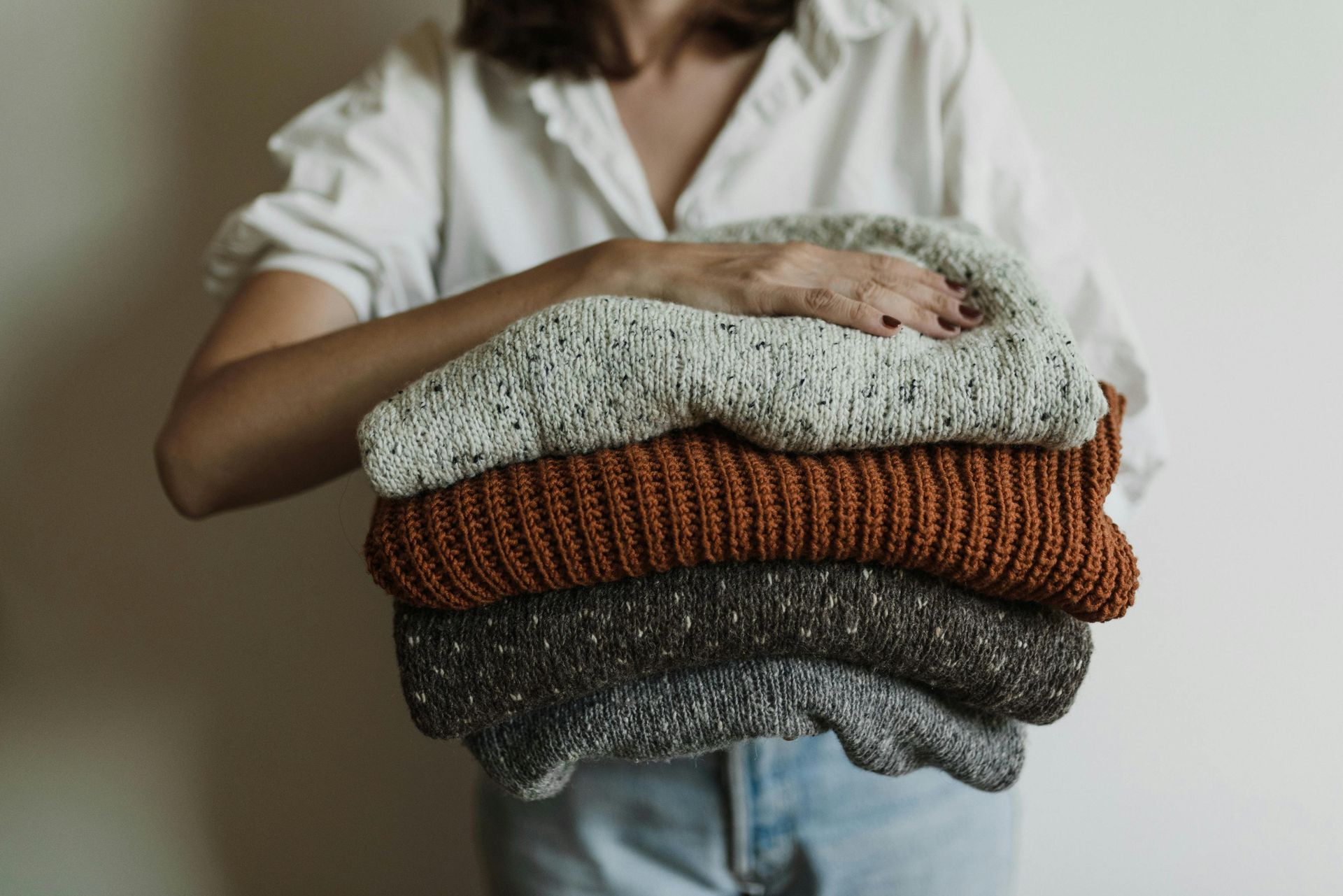 lady holding winter jumpers