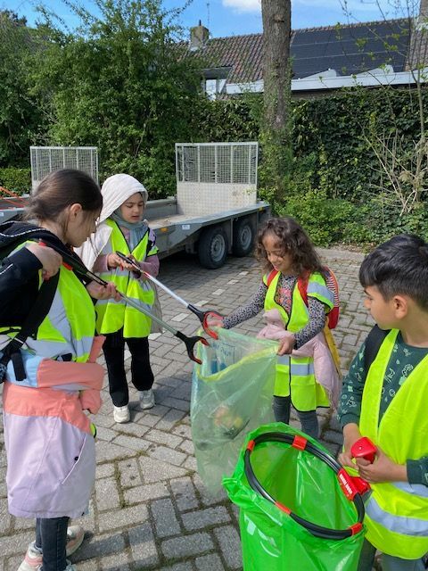 A group of children are holding lanterns in front of a car at night.