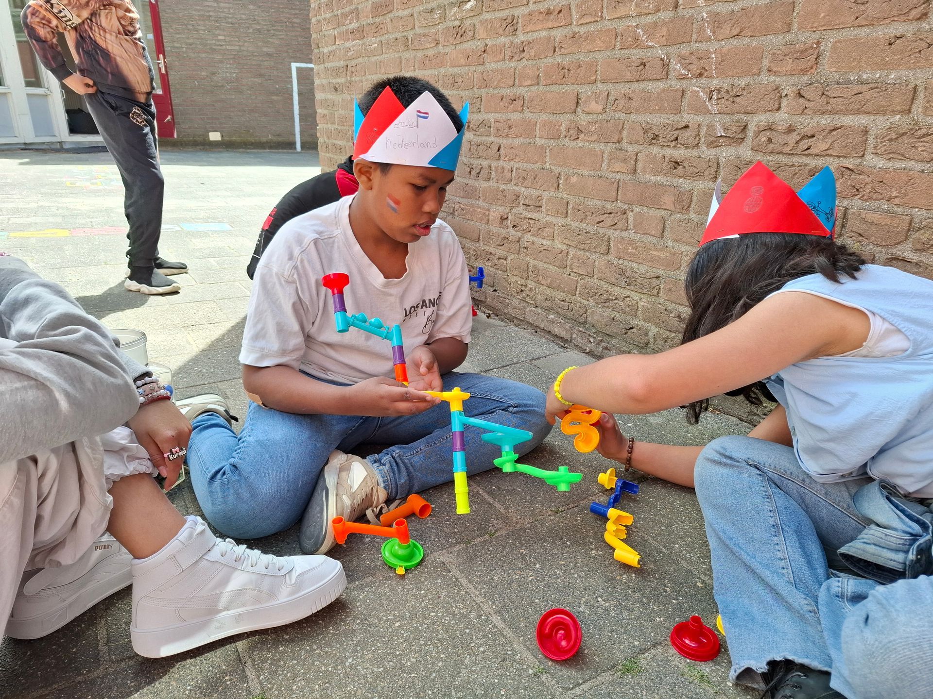 A group of children are sitting on the ground playing with toys.