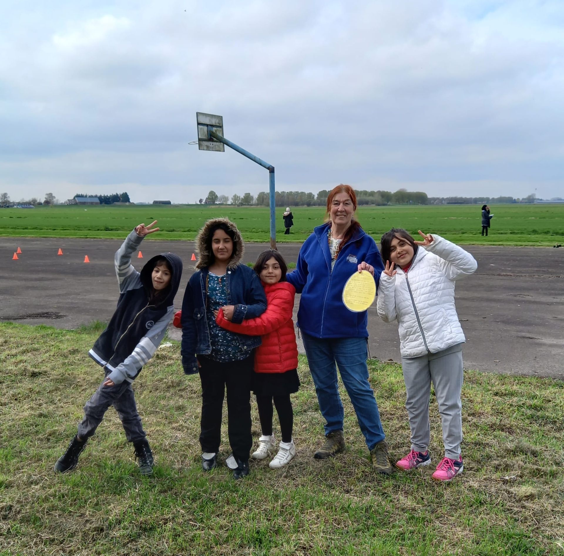 A woman and three children are posing for a picture in a field.