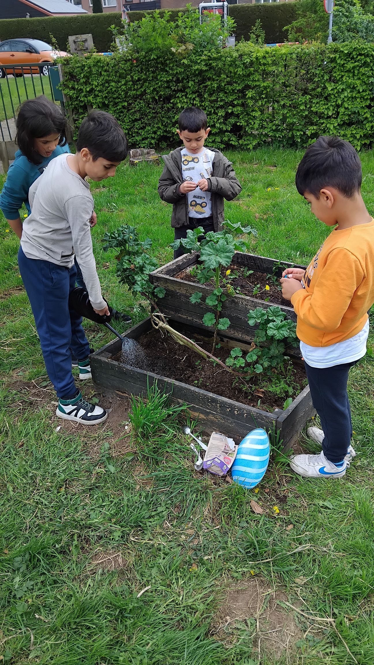 A group of children are working in a garden.