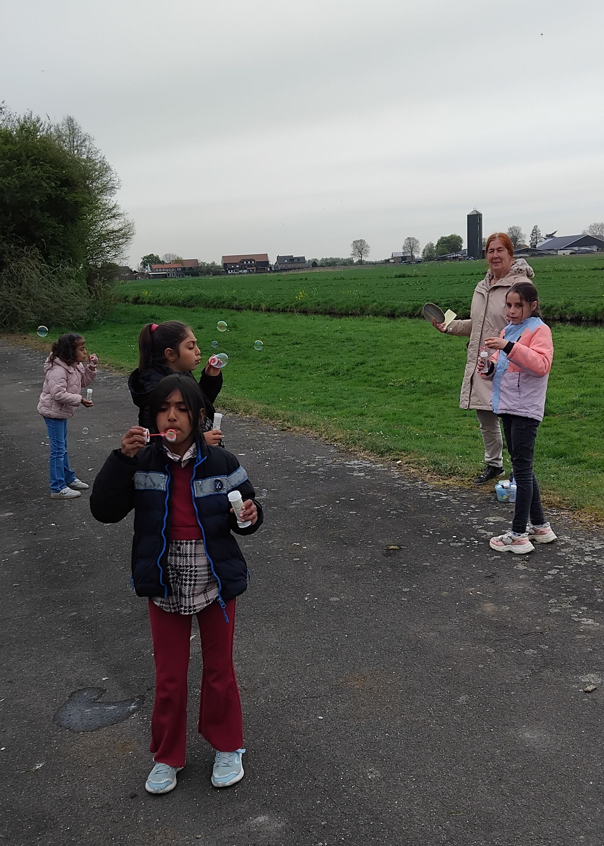 A group of children are blowing soap bubbles in a field