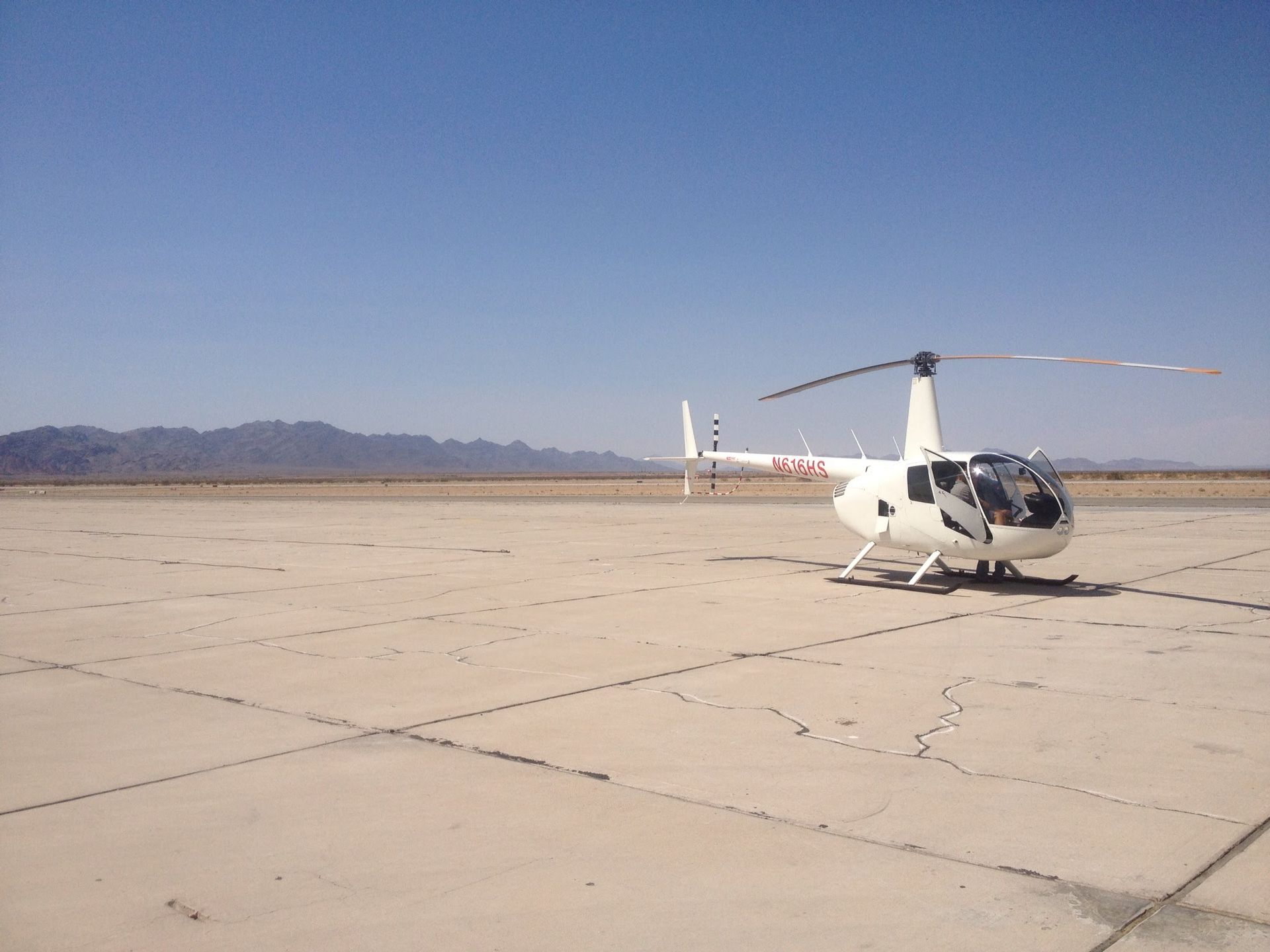 A White helicopter on an airport ramp