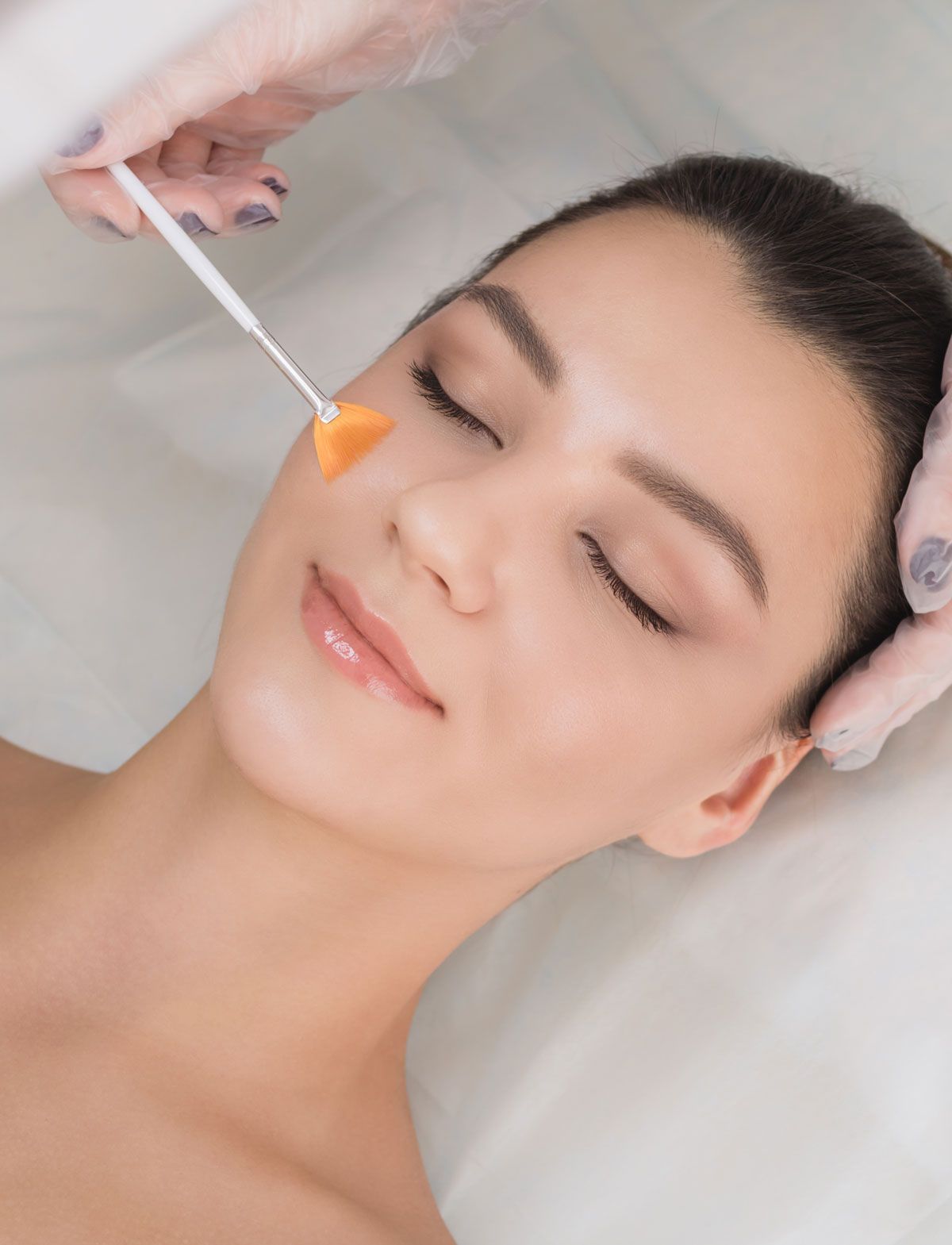 A woman is getting a facial treatment at a beauty salon.
