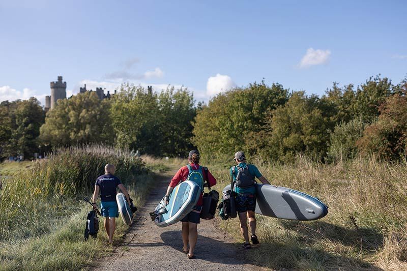 A beautiful hot air balloon takes off from a field alongside Arundel Castle