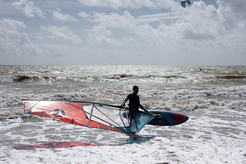 Water Sports students with their instructor and paddleboards on the shingle beach by the The Beach @Littlehampton Activity Hub and Cafe
