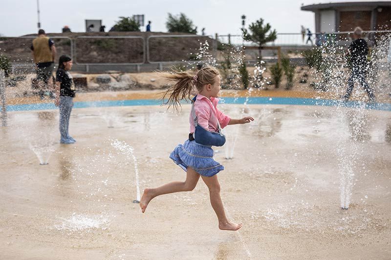 Littlehampton Golf Club course, with golfers and a backdrop of yachts on the river, riverside properties, the turrets of Arundel Castle and the South Downs beyond.