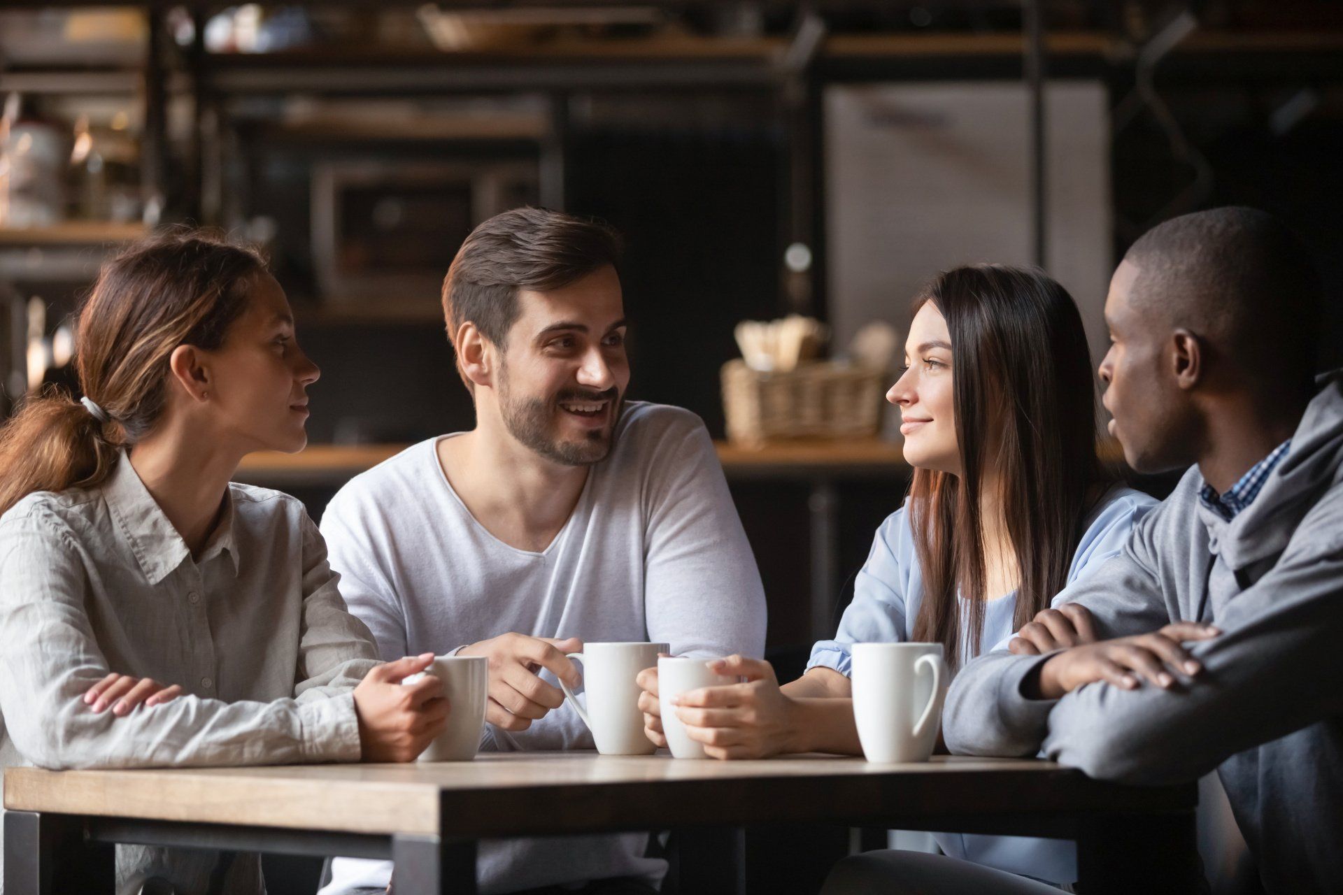 A group of people are sitting at a table talking to each other.