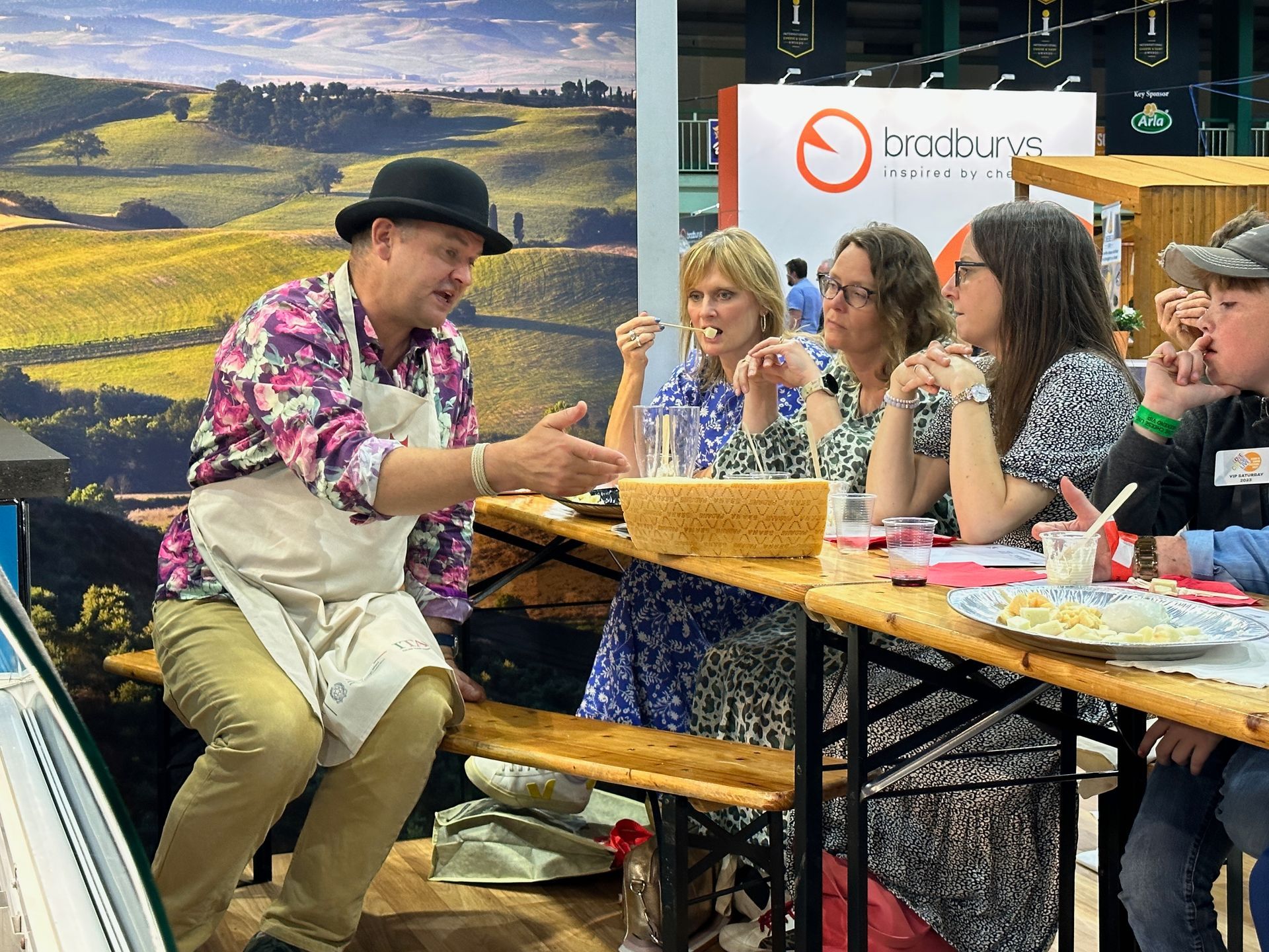 Attendees at a seminar listen intently, some with pens, in a well-lit room.