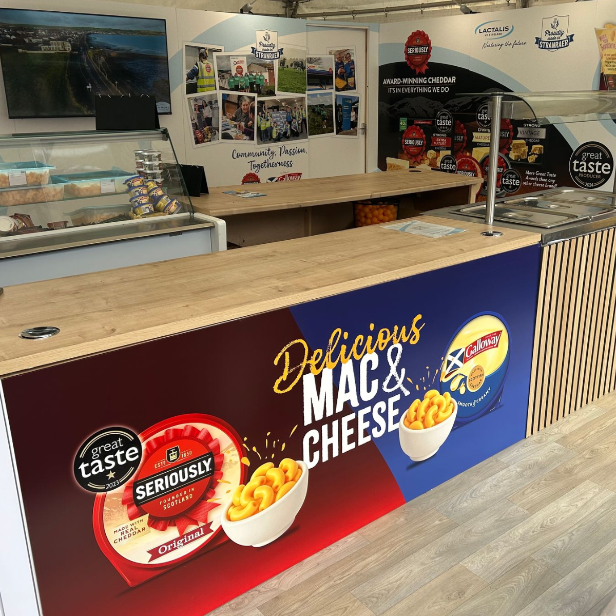 Woman in white uniform and hair net, blue gloves, processing food in a facility, smiling.