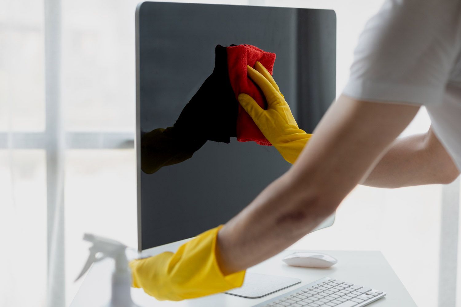 Professional Brisbane Cleaner wiping windows with gloves and safe cleaning products
