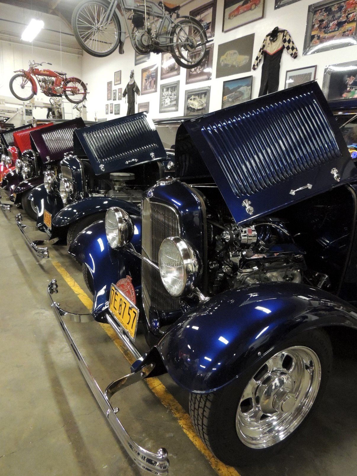 A row of old cars are lined up in a garage