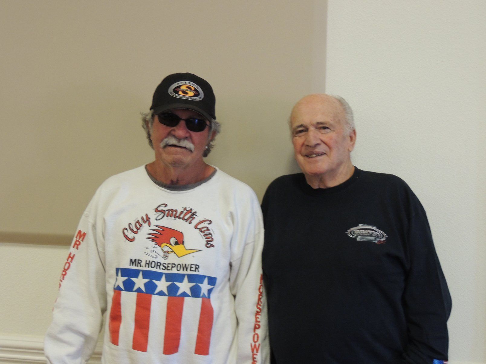 Two men standing next to each other one wearing a clay smith gear shirt