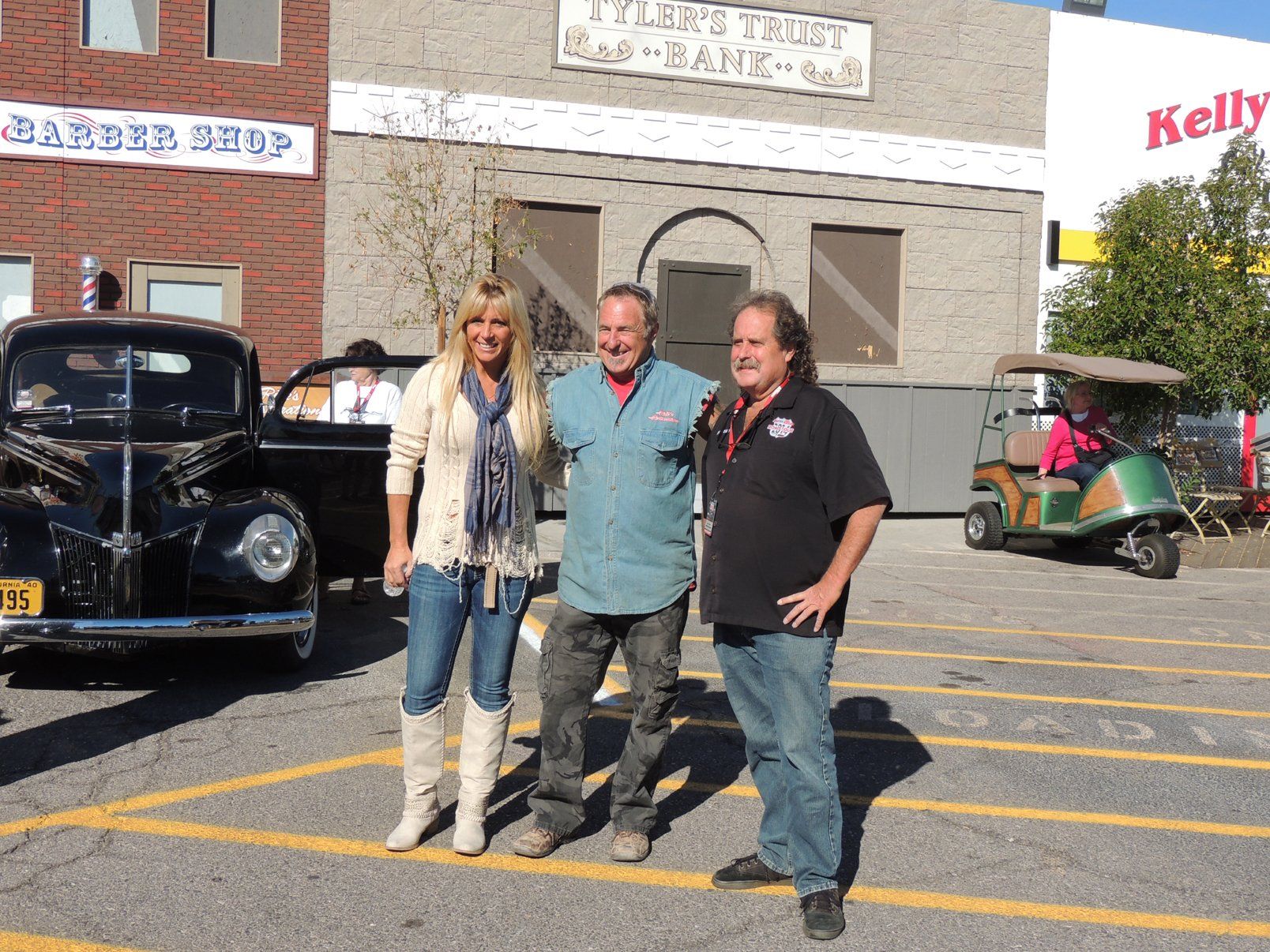 Three people are posing for a picture in front of a barber shop