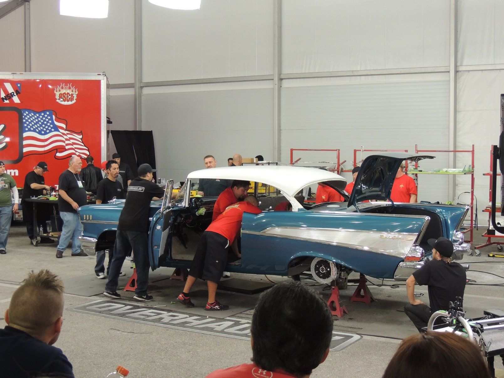 A group of men are working on a car in a garage