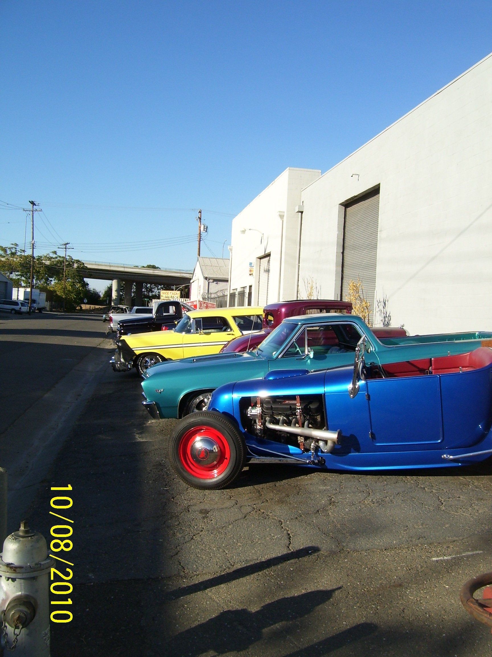 A row of cars are parked in front of a building on 10/08/2010