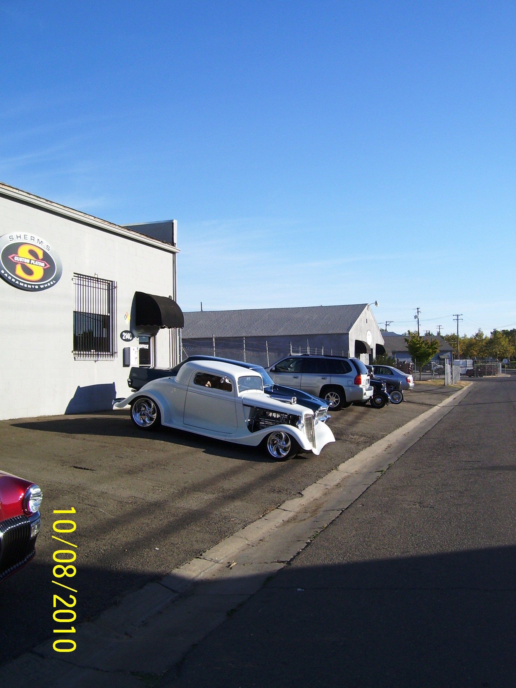A white car is parked in front of a building on 10/08/2010