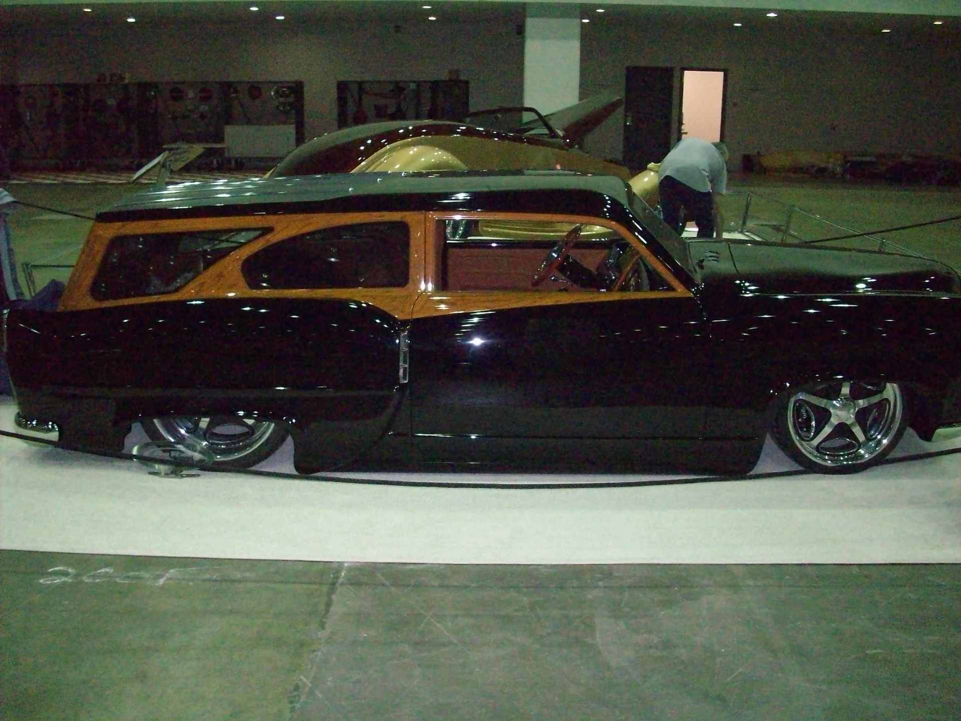 A black and orange car is on display in a building