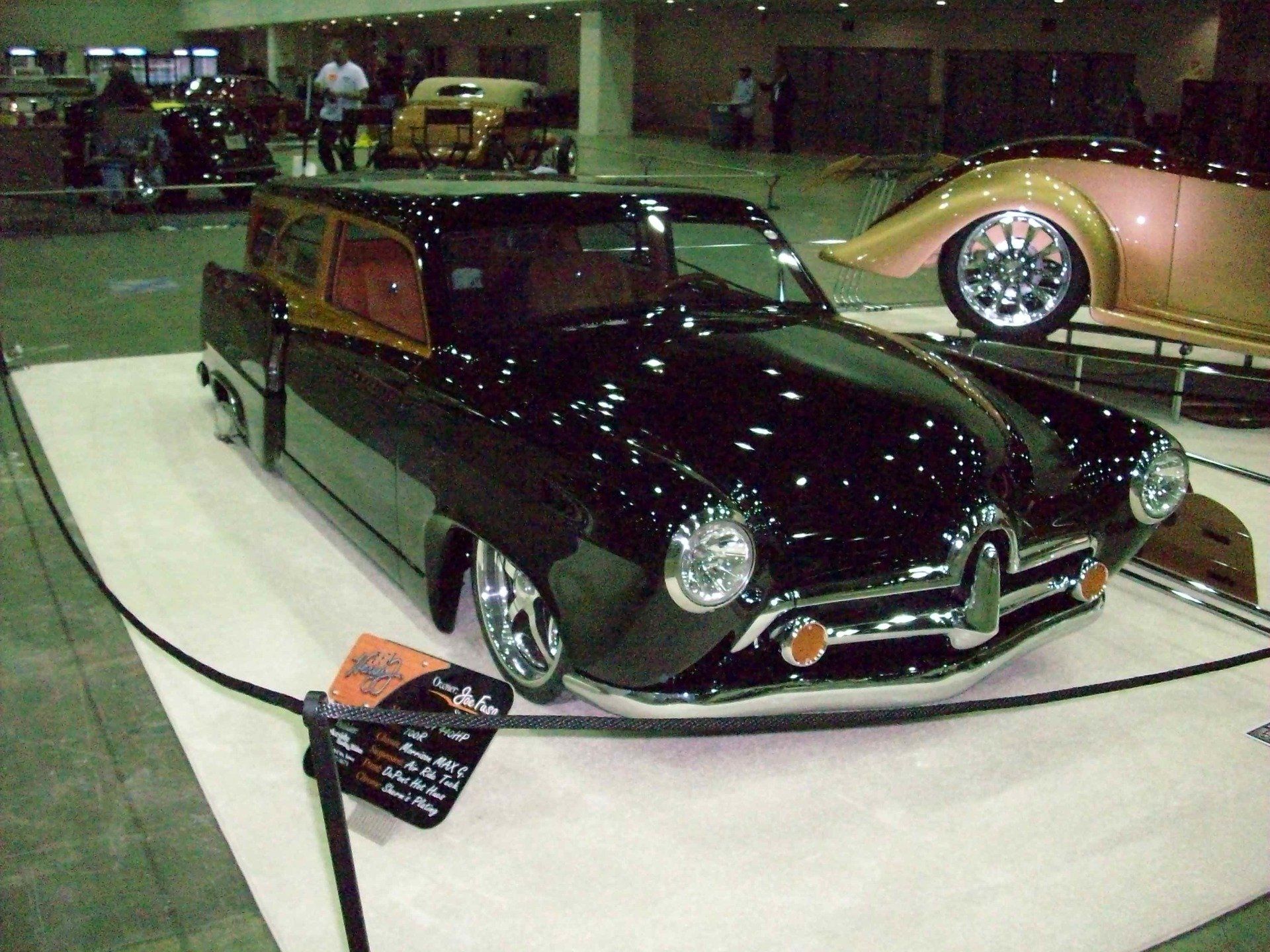 A black car is on display at a car show