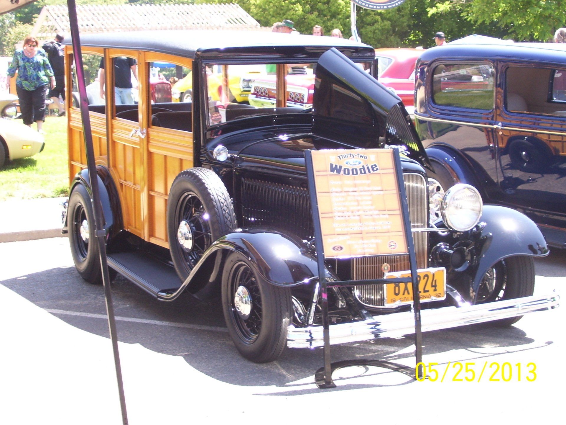 An old woody wagon is parked in a parking lot