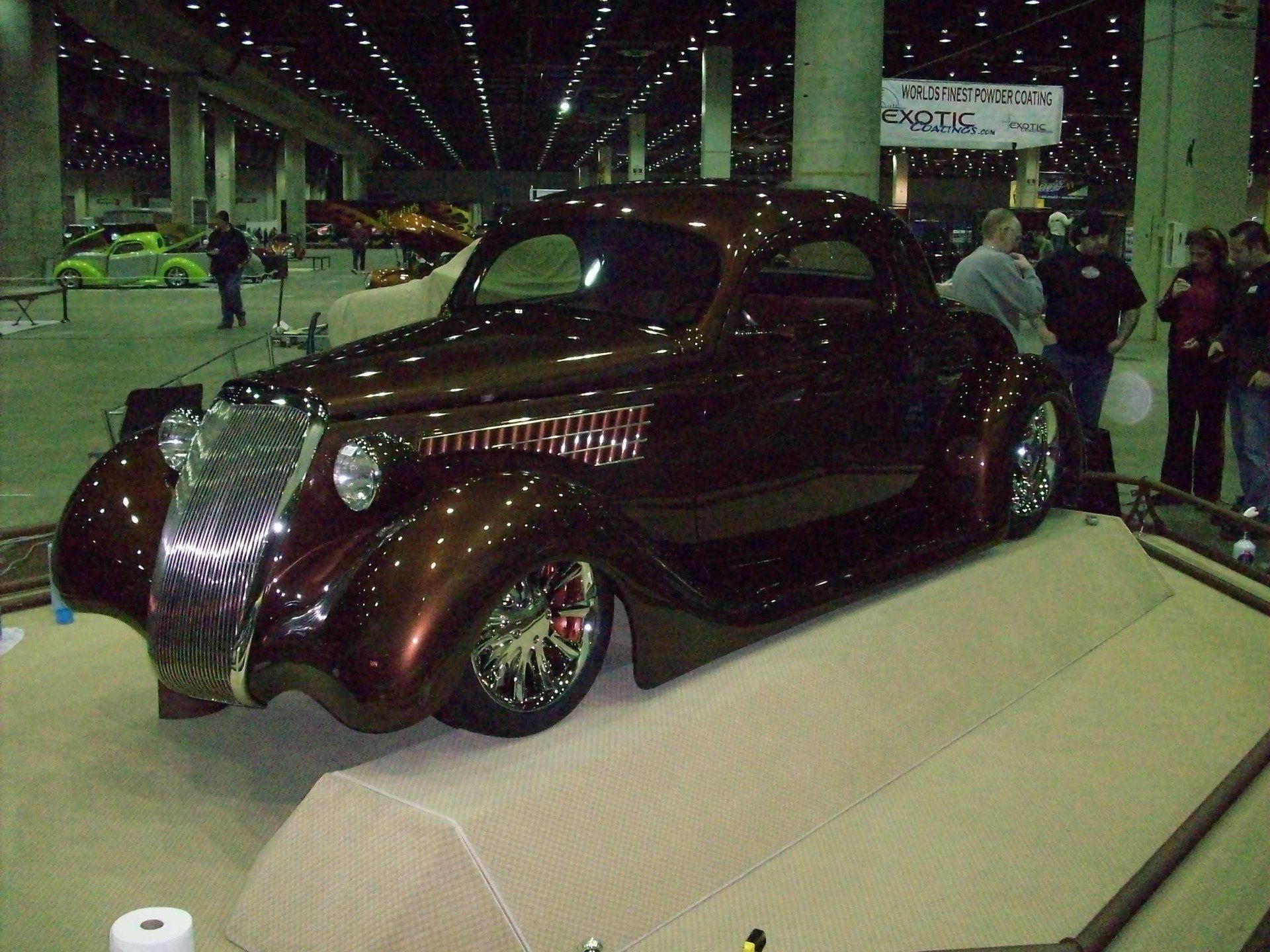 A brown car is on display at a car show