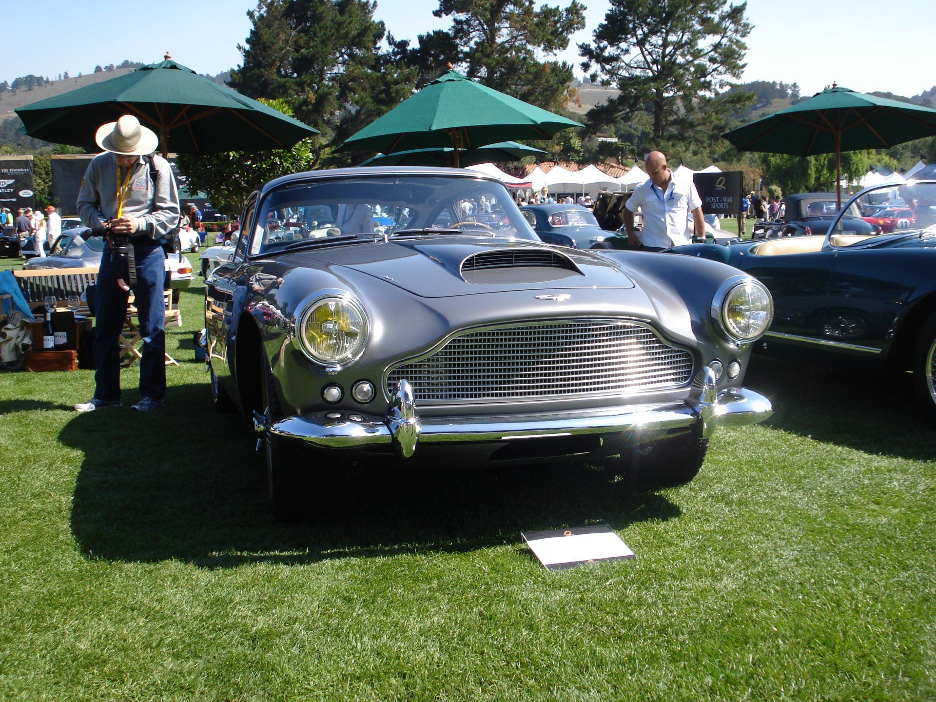 A man in a cowboy hat stands next to a car