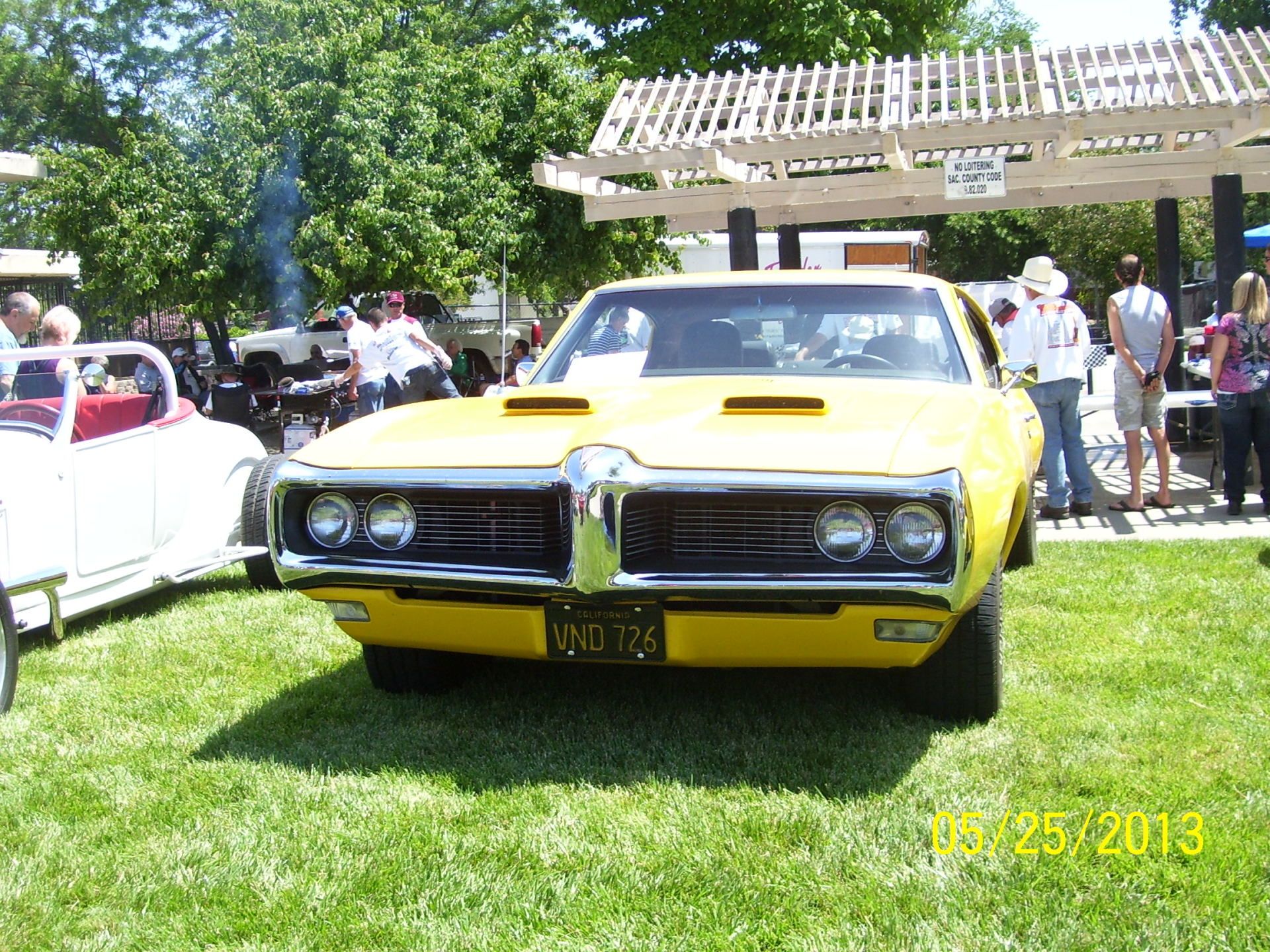 A yellow pontiac is parked in the grass