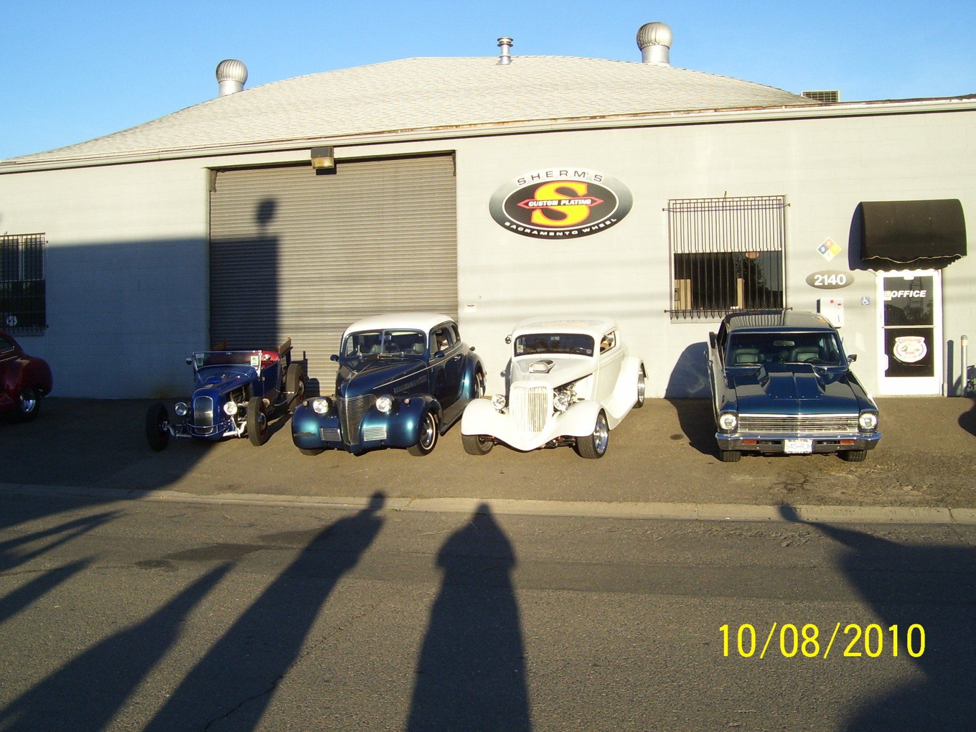 Several cars are parked in front of a building with the letter s on it