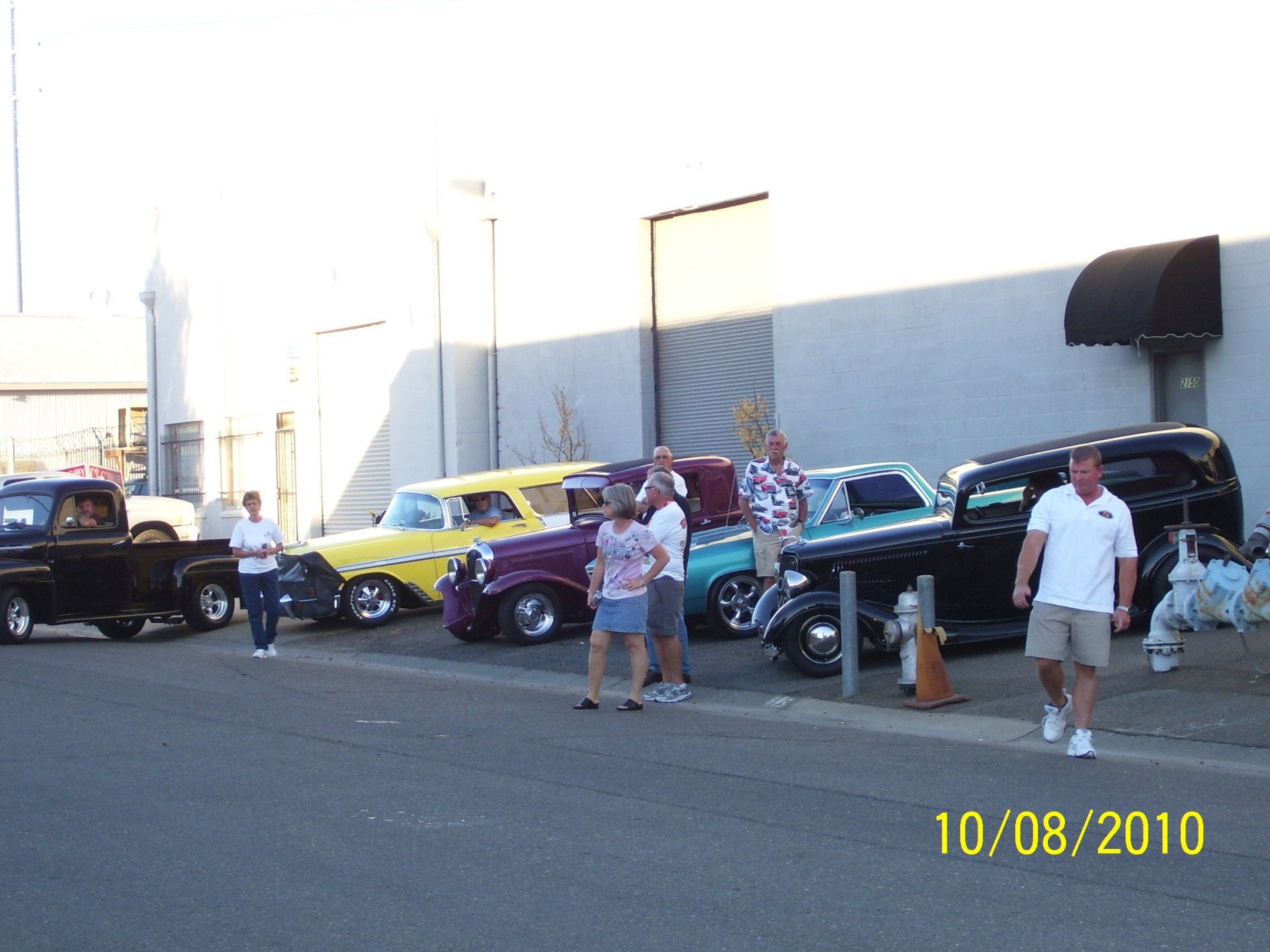 A photo taken on 10/08/2010 shows a group of people standing in front of cars
