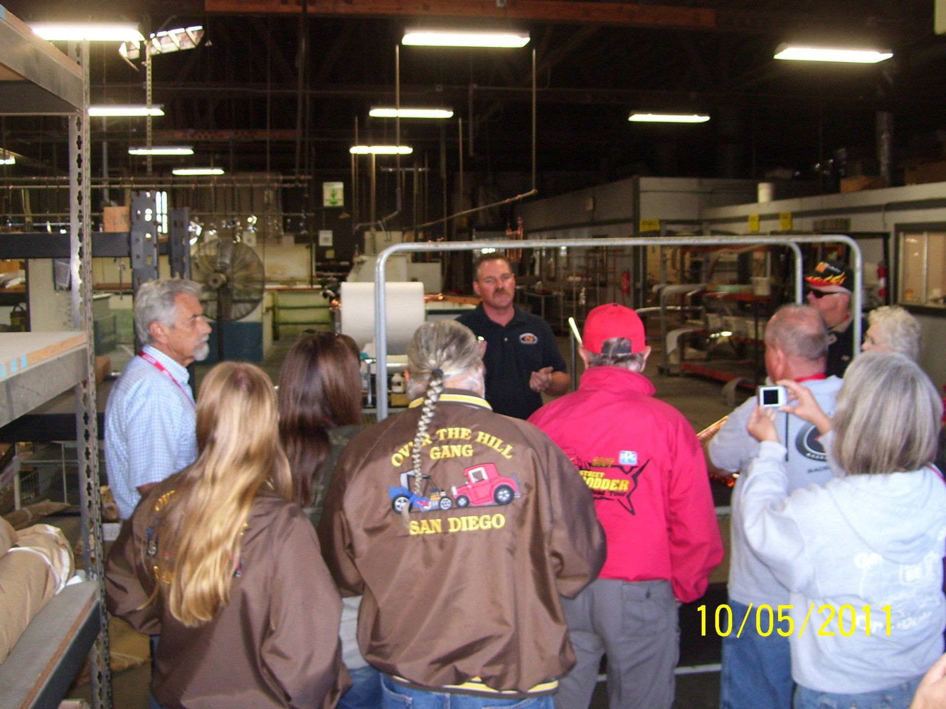 A group of people are gathered in a warehouse wearing jackets that say san diego