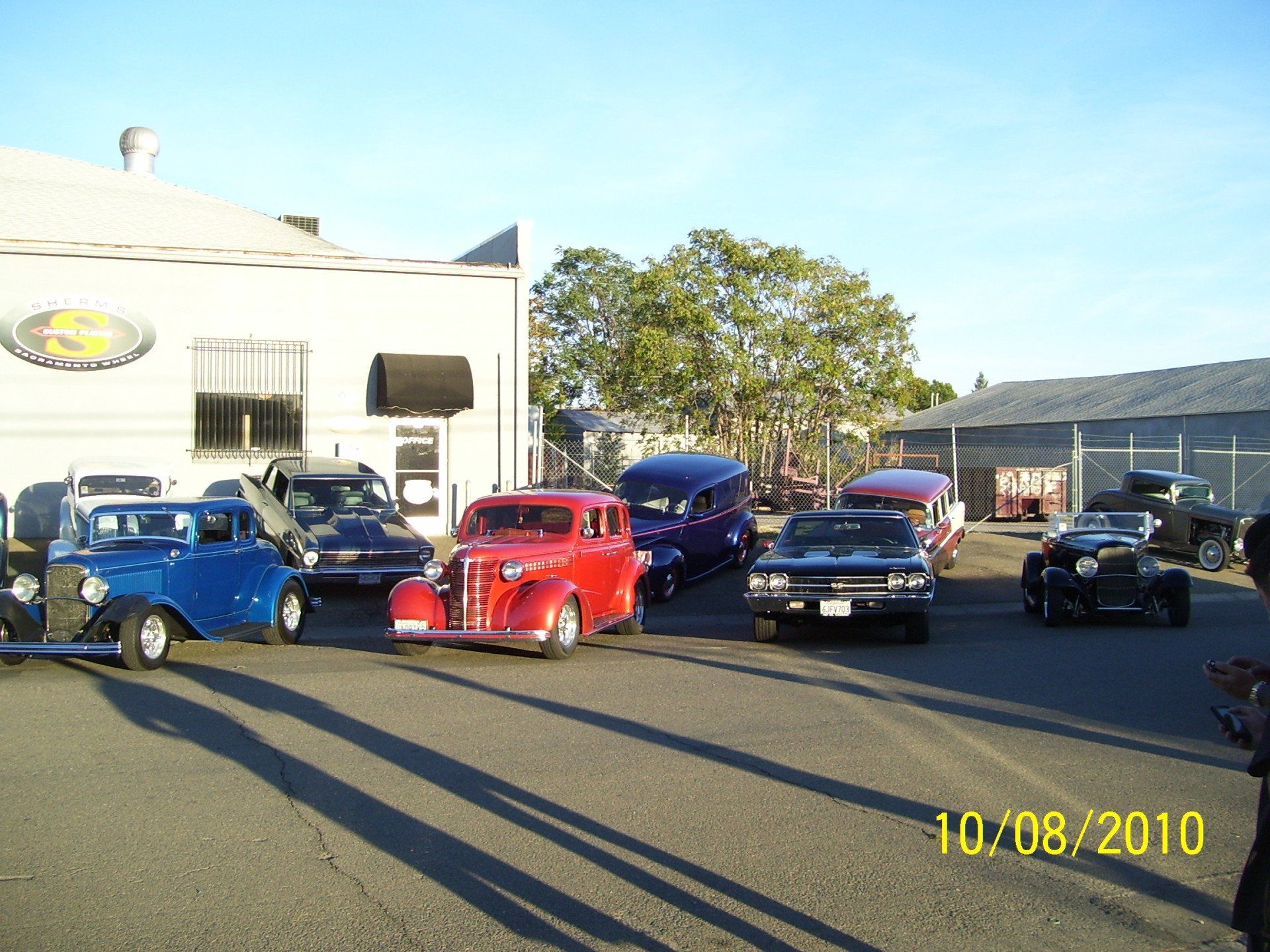 A group of cars are parked in front of a building on 10/08/2010
