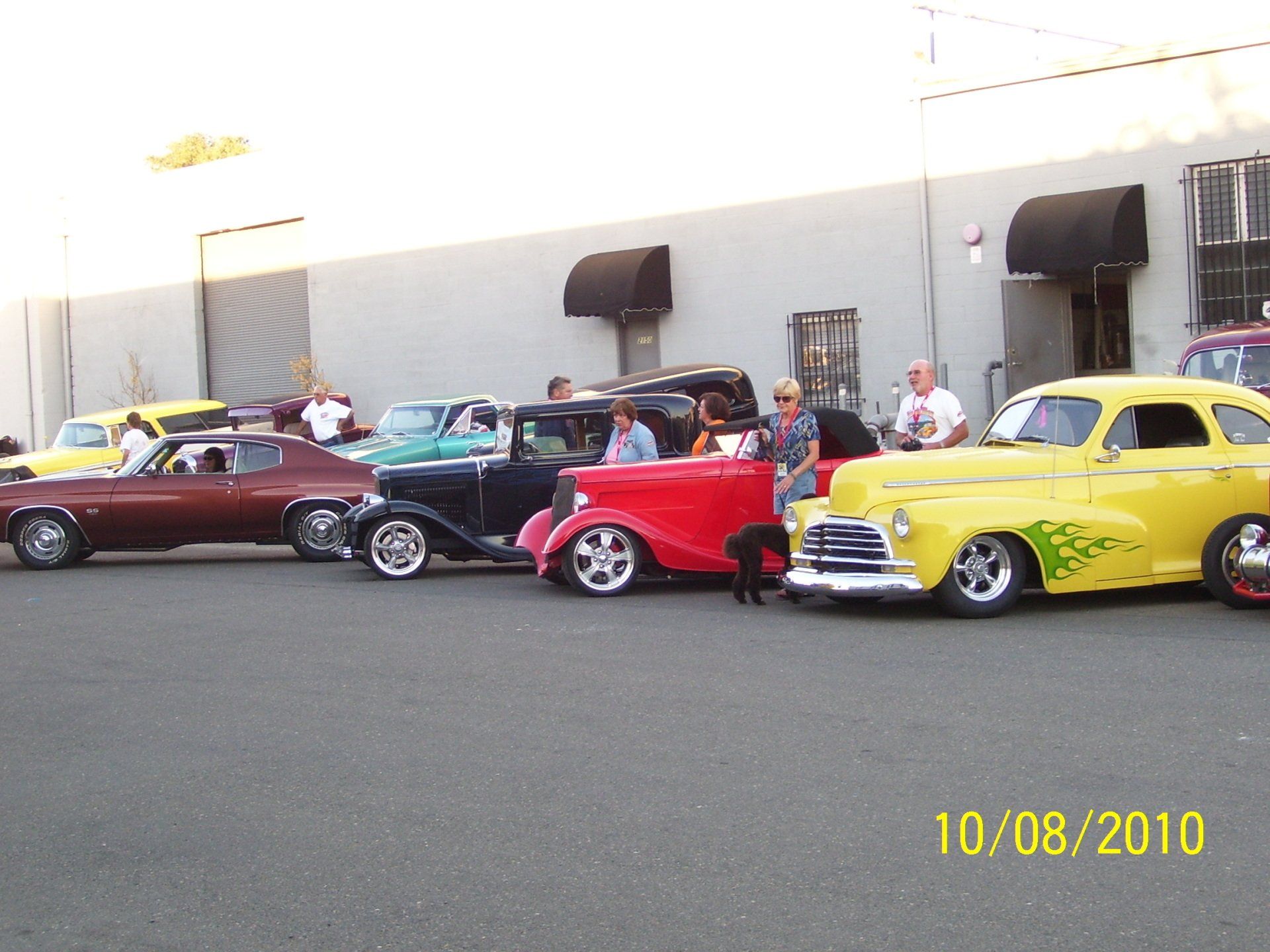 A row of old cars are parked in front of a building on 10/08/2010