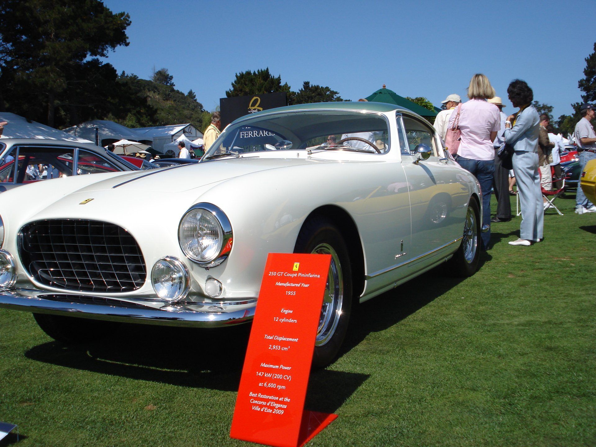 A white car is on display at a car show