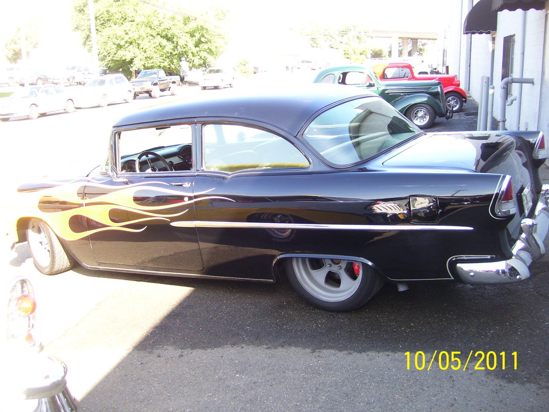A black car is parked in a parking lot on 10/05/11