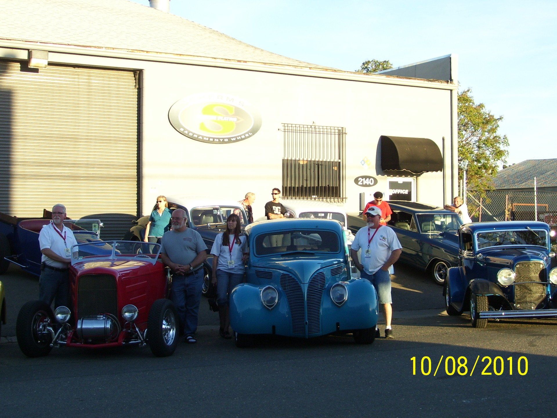 A group of old cars are parked in front of a building on 10/08/2010