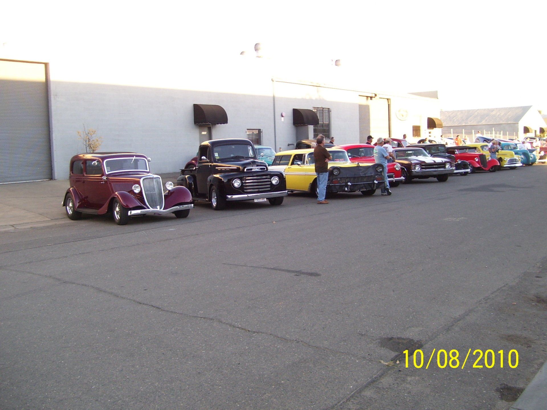 A row of cars are parked in front of a building on 10/08/2010