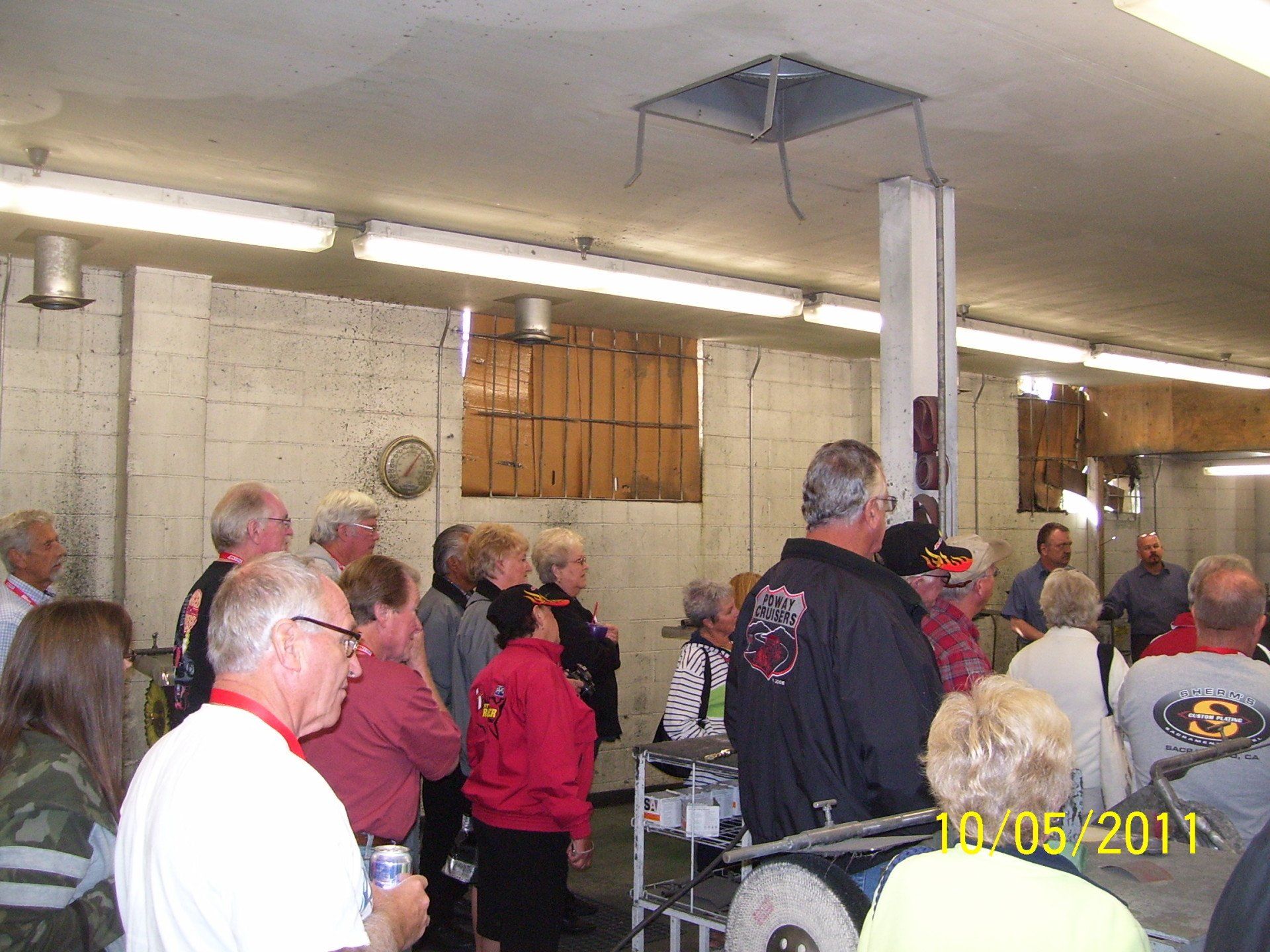 A group of people standing in a room with the date 10/05/11